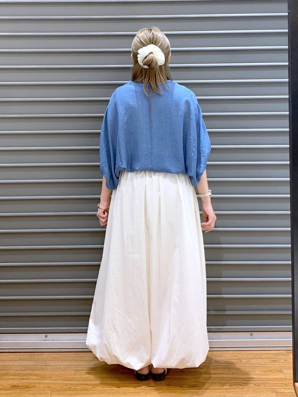 ホワイト系のサンダル、ホワイト系のスカート、グレー系のショルダーバッグを着用したレディースの夏コーディネートの2枚目の写真