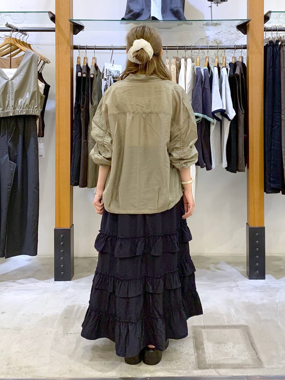 ホワイト系のタンクトップ、ブルー系のスカート、グレー系のショルダーバッグを着用したレディースの秋コーディネートの2枚目の写真