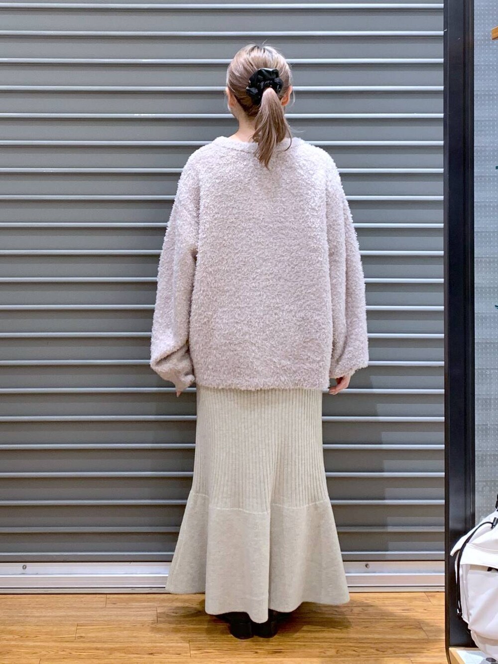 ブラック系のショルダーバッグ、ブラック系のブーツ、ホワイト系のワンピースを着用したレディースの冬コーディネートの2枚目の写真