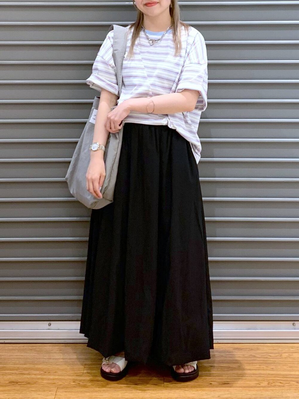ホワイト系のサンダル、グレー系のトートバッグ、ブラック系のスカートを着用したレディースの夏コーディネートの5枚目の写真