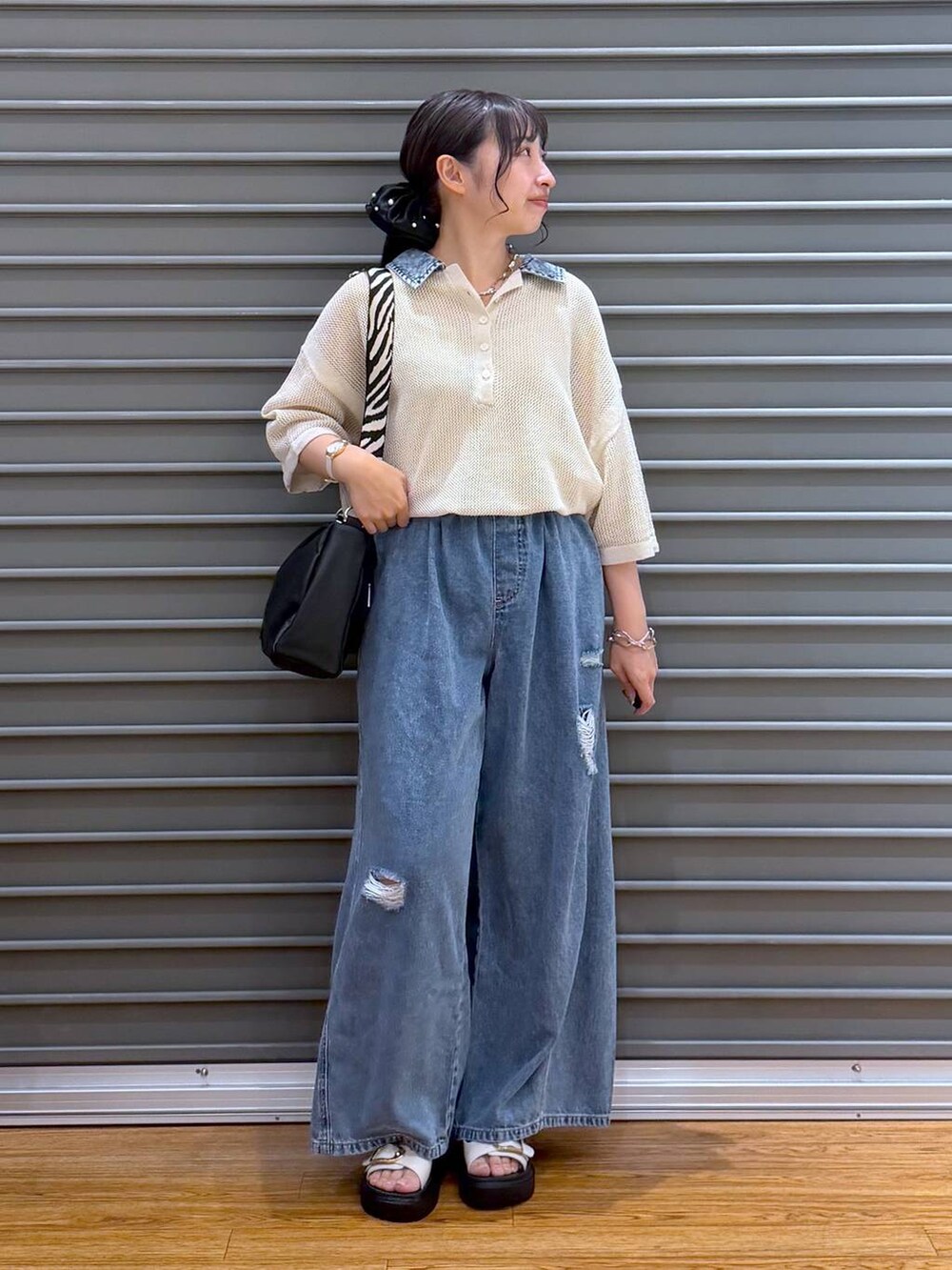 ブルー系のデニムパンツ、ホワイト系のサンダル、ブラック系のショルダーバッグを着用したレディースの夏コーディネートの5枚目の写真