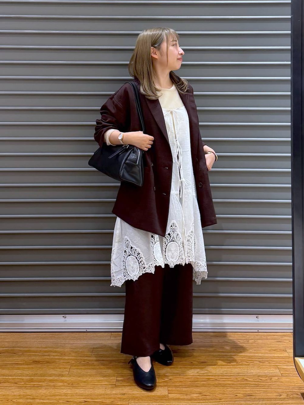 ブラック系のボストンバッグ、ホワイト系のキャミソール、ブラウン系のその他パンツを着用したレディースの春コーディネートの4枚目の写真