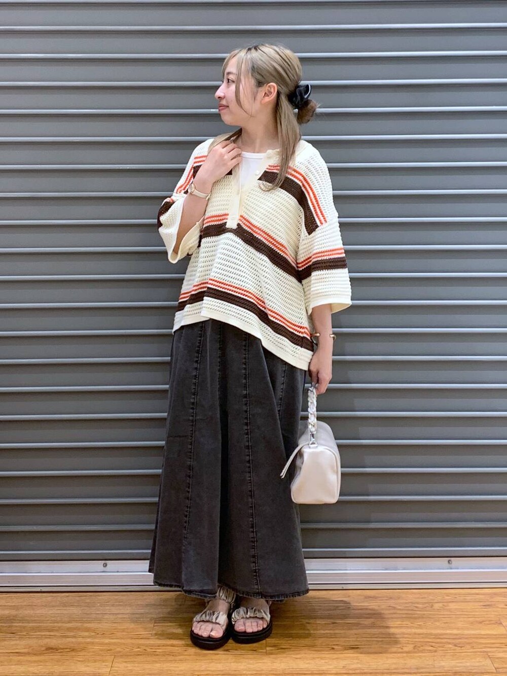 ベージュ系のサンダル、グレー系のスカート、ホワイト系のショルダーバッグを着用したレディースの春コーディネートの6枚目の写真