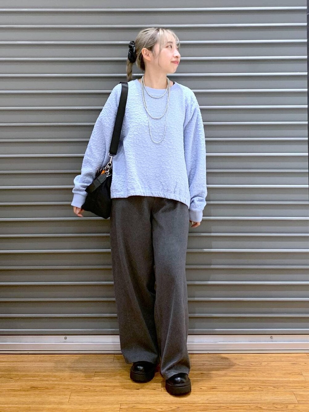 ブラック系のショルダーバッグ、グレー系のその他パンツ、ブラック系のブーツを着用したレディースの秋コーディネートの4枚目の写真