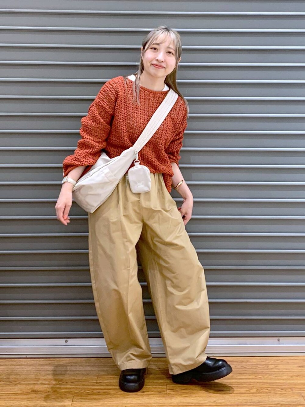 レッド系のニット/セーター、ホワイト系のショルダーバッグ、ブラック系のサンダルを着用したレディースの春コーディネートの5枚目の写真