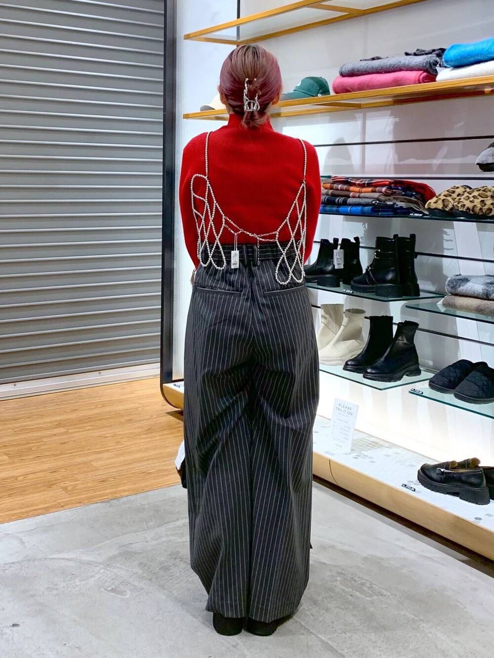 ホワイト系のベスト、ブラック系のブーツ、ブラック系のショルダーバッグを着用したレディースの冬コーディネートの2枚目の写真