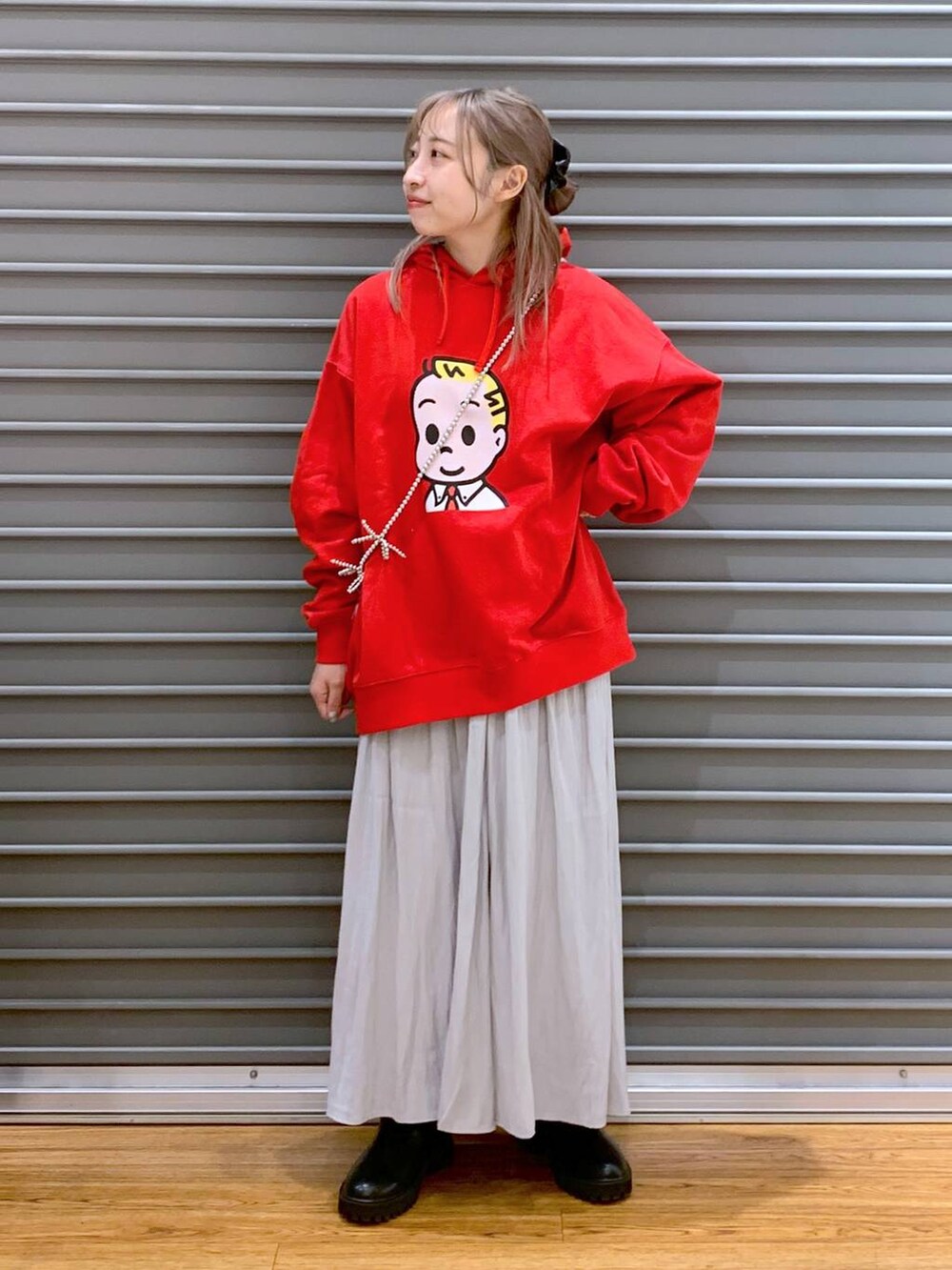 グレー系のその他パンツ、ブラック系のブーツ、レッド系のパーカーを着用したレディースの冬コーディネートの3枚目の写真