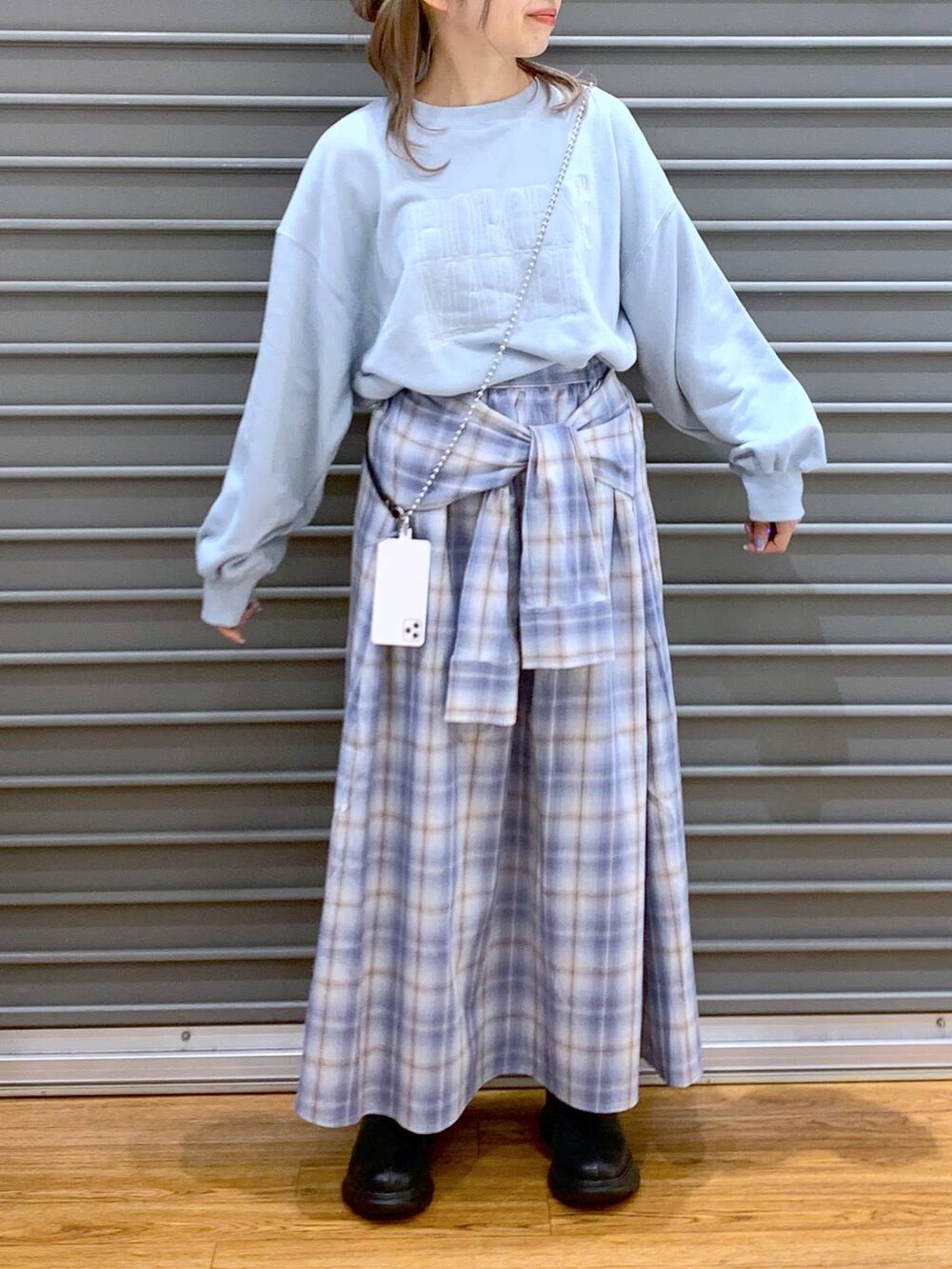 ブラック系のブーツ、ブルー系のスカート、ブルー系のスウェットを着用したレディースの冬コーディネートの5枚目の写真