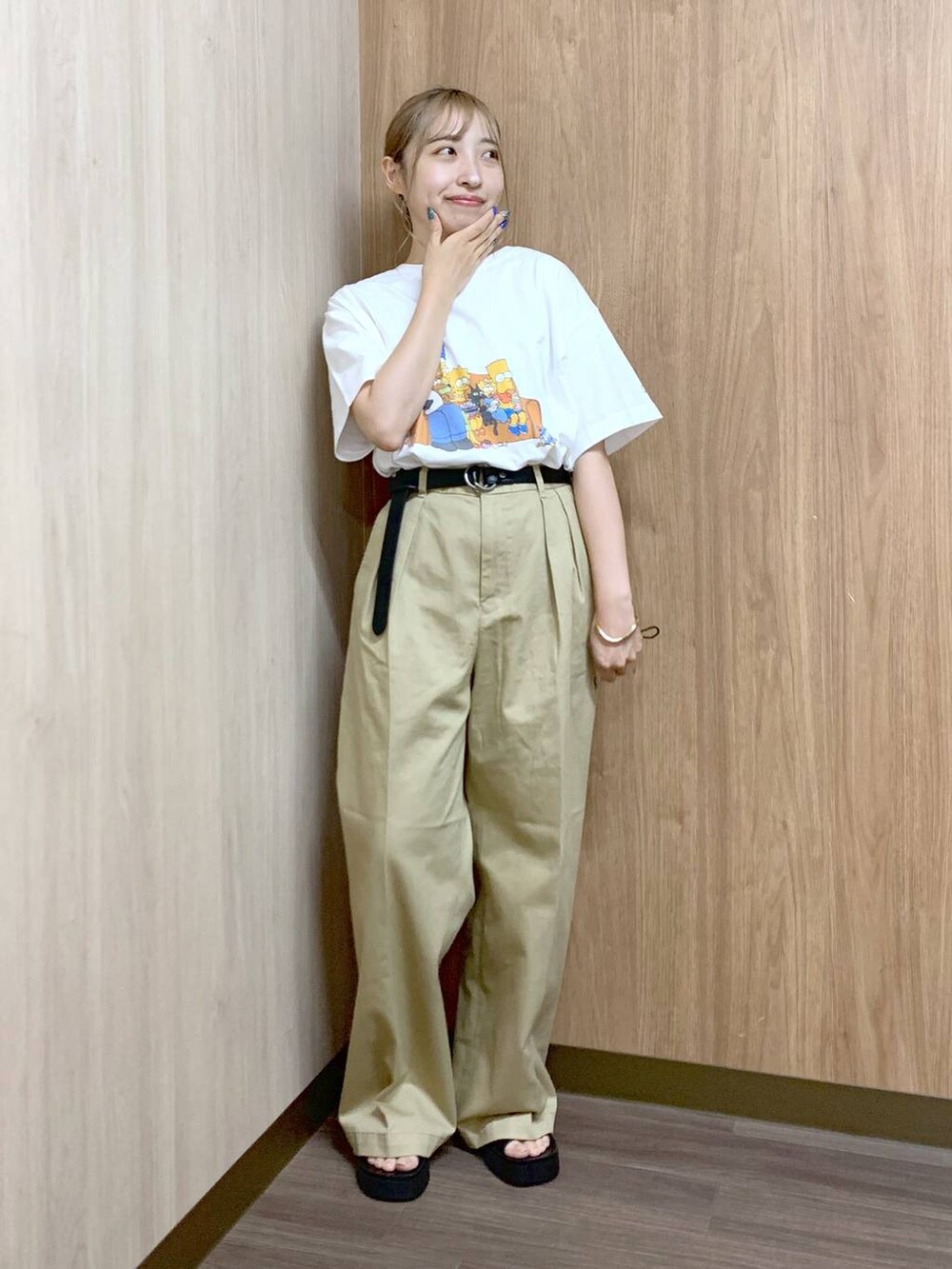 ベージュ系のチノパンツ、ブラック系のサンダル、ホワイト系のTシャツ/カットソーを着用したレディースの夏コーディネートの4枚目の写真