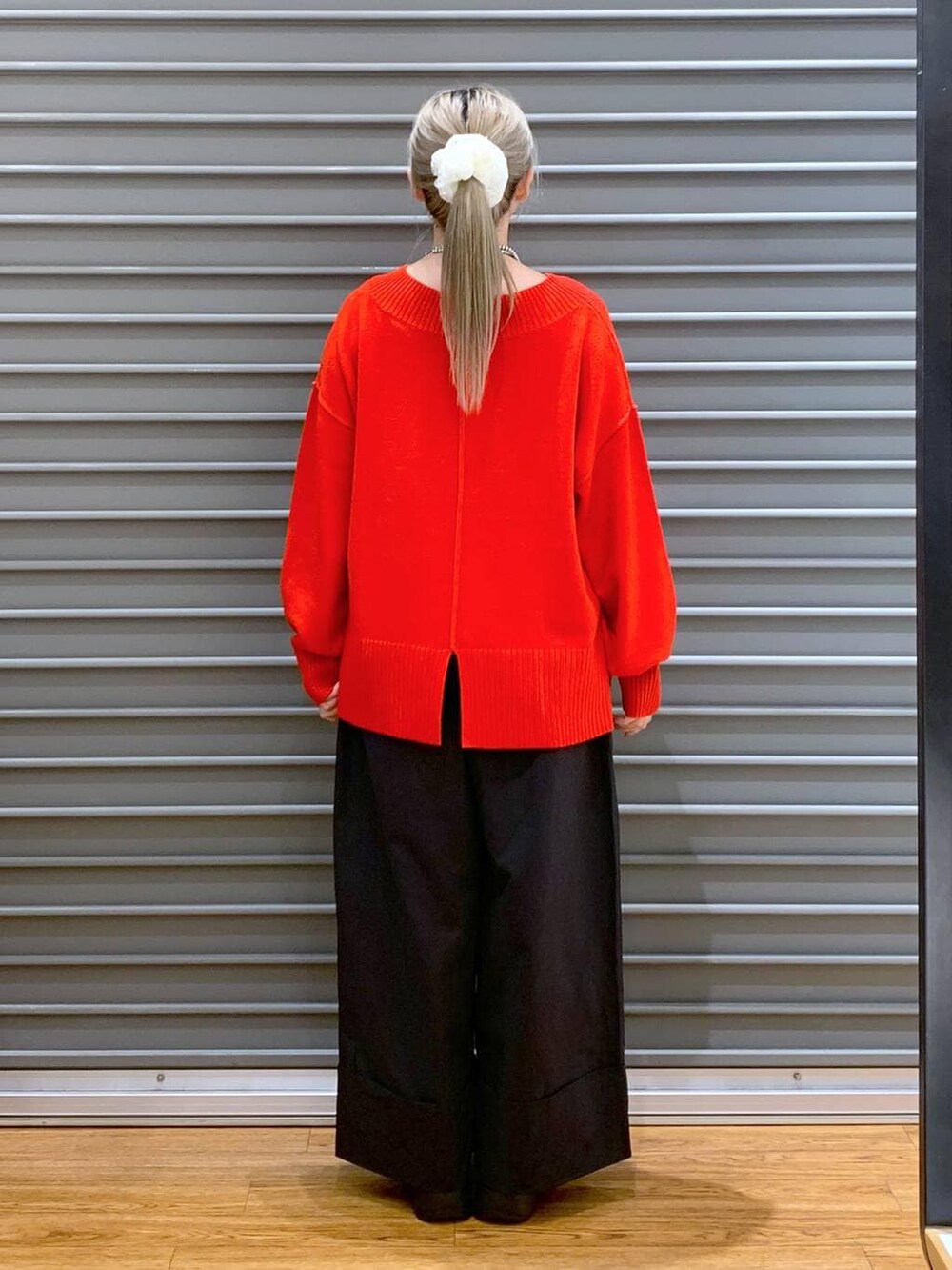 レッド系のニット/セーター、ブラック系のショルダーバッグ、ブラック系のブーツを着用したレディースの冬コーディネートの3枚目の写真