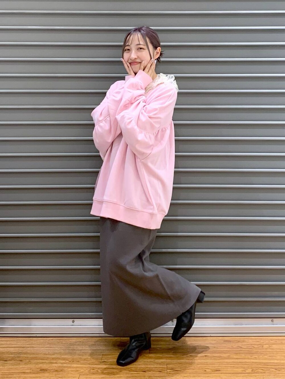 グレー系のスカート、ブラック系のブーツ、ピンク系のスウェットを着用したレディースの冬コーディネートの4枚目の写真