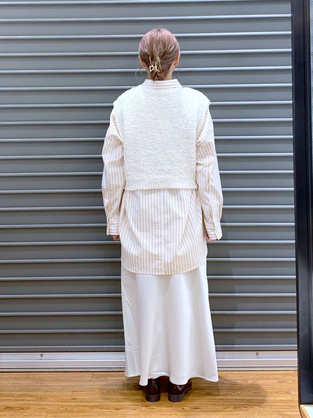 シルバー系のショルダーバッグ、ホワイト系のスカート、オレンジ系のシャツ/ブラウスを着用したレディースの秋コーディネートの2枚目の写真