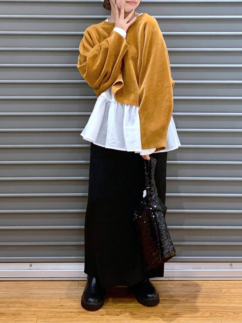 ブラック系のブーツ、ブラック系のスカート、ホワイト系のTシャツ/カットソーを着用したレディースの秋コーディネートの5枚目の写真