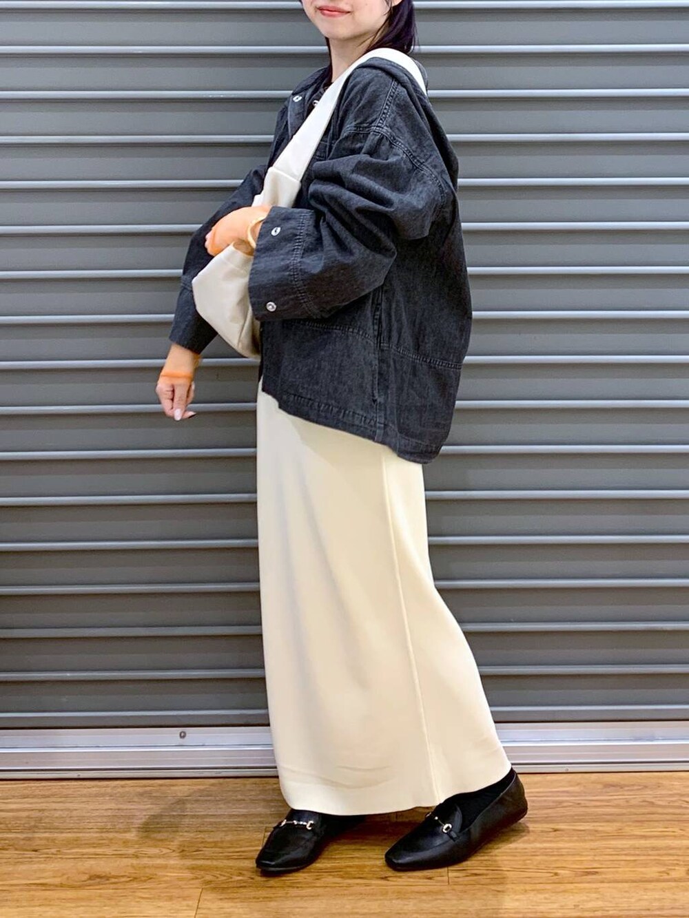 ブラック系のTシャツ/カットソー、ブラック系のローファー、ホワイト系のスカートを着用したレディースの春コーディネートの4枚目の写真