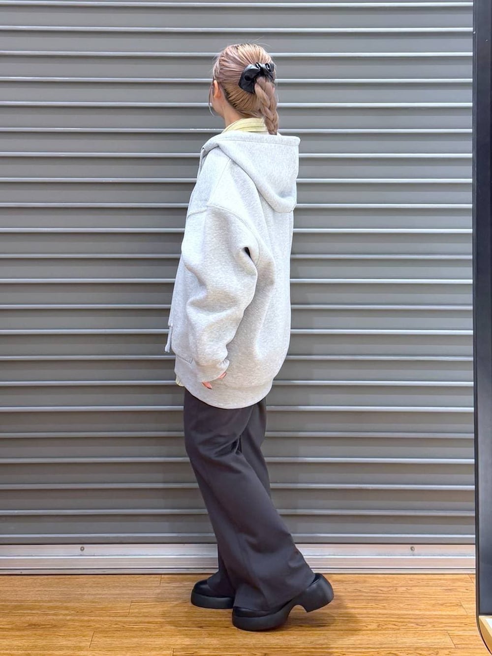 ブラック系のサンダル、ブラック系のボストンバッグ、グレー系のパーカーを着用したレディースの冬コーディネートの4枚目の写真