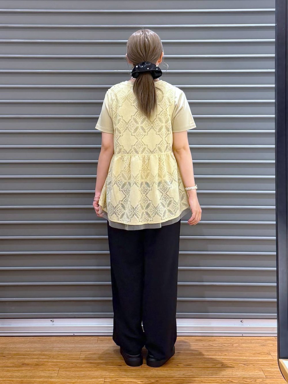 ブラック系のトートバッグ、ホワイト系のサンダル、ベージュ系のTシャツ/カットソーを着用したレディースの夏コーディネートの2枚目の写真