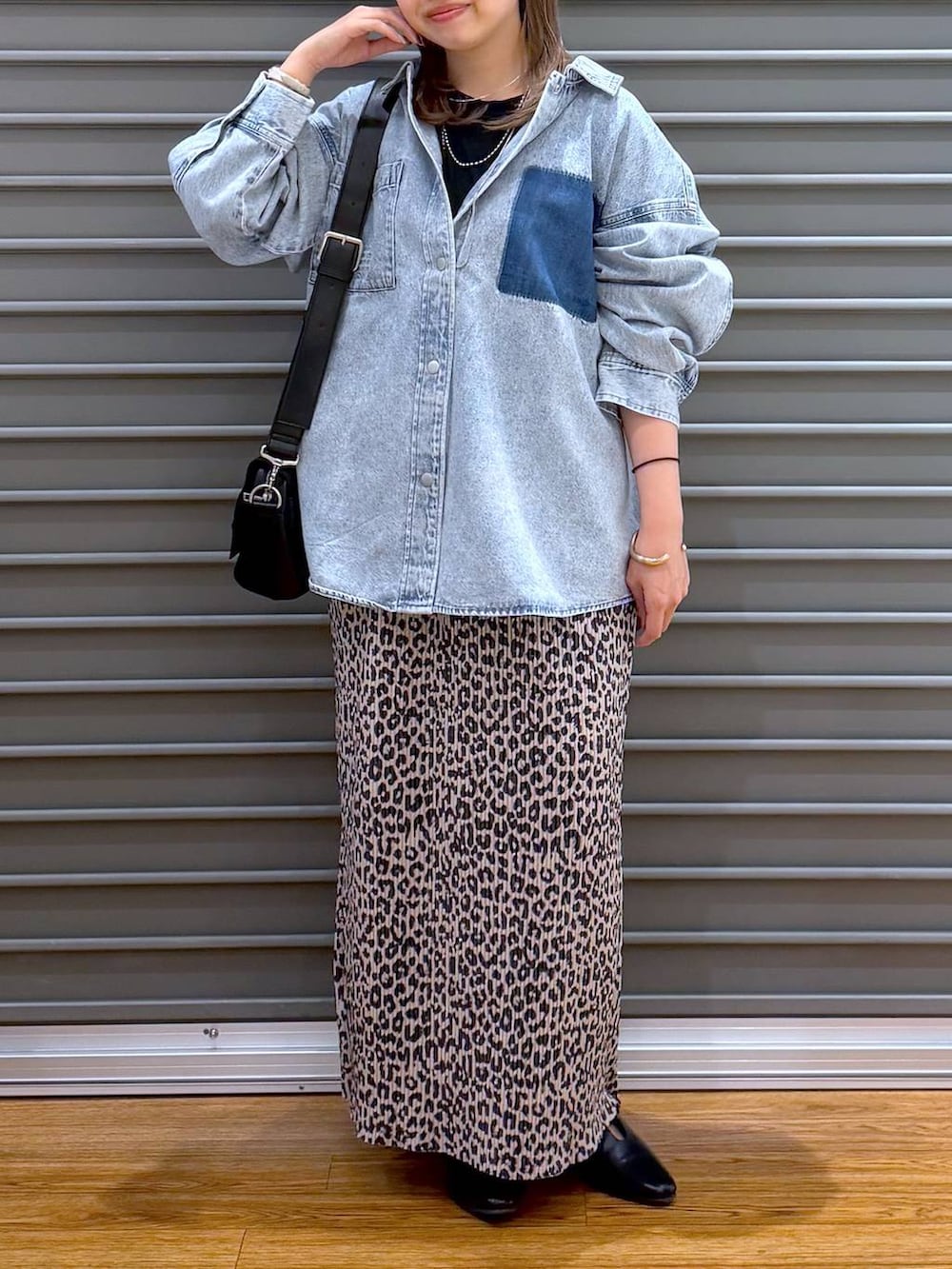 ブラック系のショルダーバッグ、ブルー系のシャツ/ブラウス、ブラック系のパンプスを着用したレディースの春コーディネートの5枚目の写真