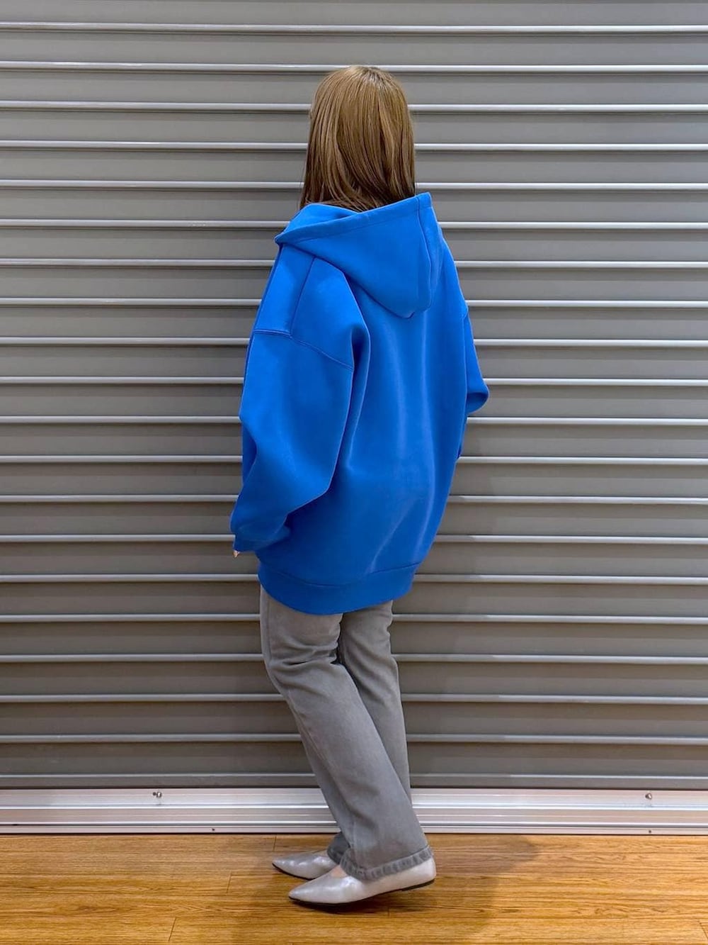 ブルー系のパーカー、ブラック系のTシャツ/カットソー、シルバー系のパンプスを着用したレディースの春コーディネートの3枚目の写真