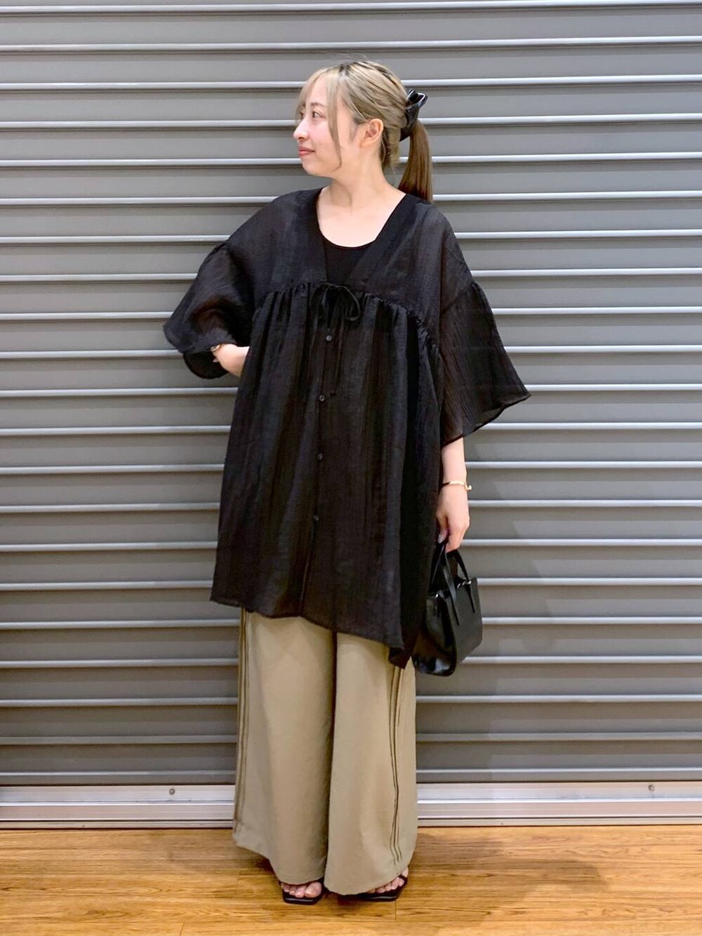 ブラック系のタンクトップ、ブラック系のショルダーバッグ、ベージュ系のその他パンツを着用したレディースの夏コーディネートの6枚目の写真