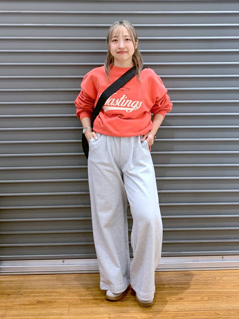 ホワイト系のスニーカー、ブラック系のショルダーバッグ、レッド系のスウェットを着用したレディースの冬コーディネートの4枚目の写真