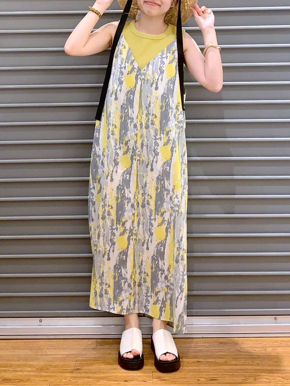 イエロー系のワンピース、イエロー系のタンクトップ、ホワイト系のショルダーバッグを着用したレディースの春コーディネートの5枚目の写真