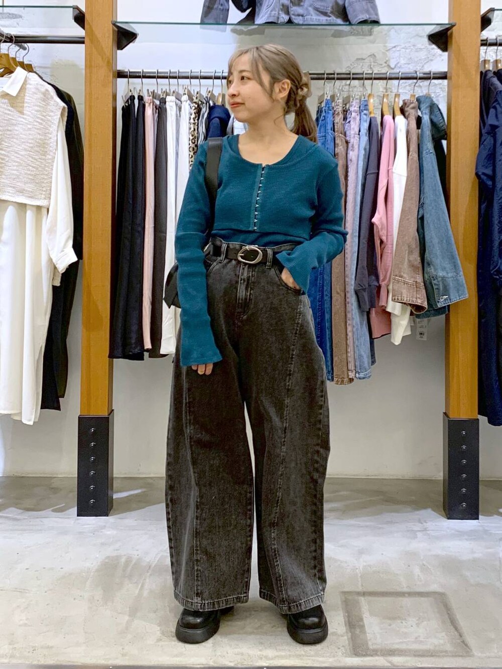 グリーン系のTシャツ/カットソー、ブラック系のデニムパンツ、ブラック系のショルダーバッグを着用したレディースの春コーディネートの5枚目の写真