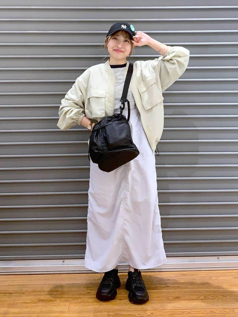 ブラック系のスニーカー、グレー系のTシャツ/カットソー、グレー系のスカートを着用したレディースの春コーディネートの8枚目の写真