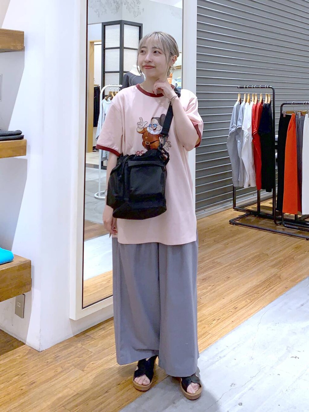 ブラック系のショルダーバッグ、ブラック系のサンダル、グレー系のスラックスを着用したレディースの夏コーディネートの3枚目の写真