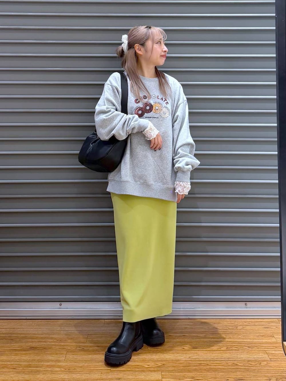 グリーン系のスカート、ブラック系のブーツ、グレー系のスウェットを着用したレディースの冬コーディネートの7枚目の写真