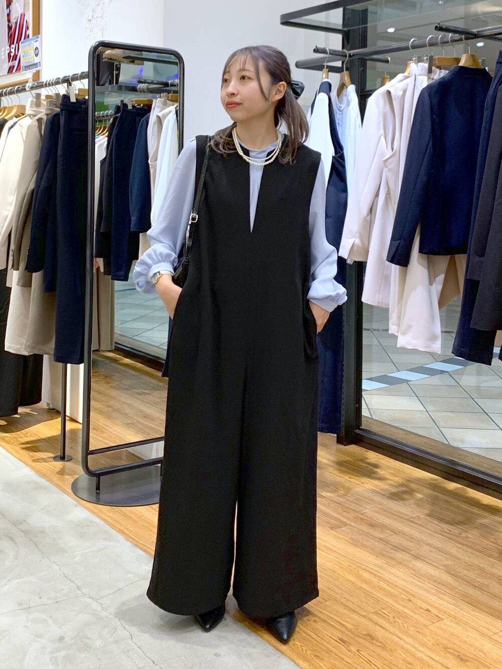 ブルー系のシャツ/ブラウス、ブラック系のサロペット/オーバーオール、ブラック系のパンプスを着用したレディースの冬コーディネートの4枚目の写真