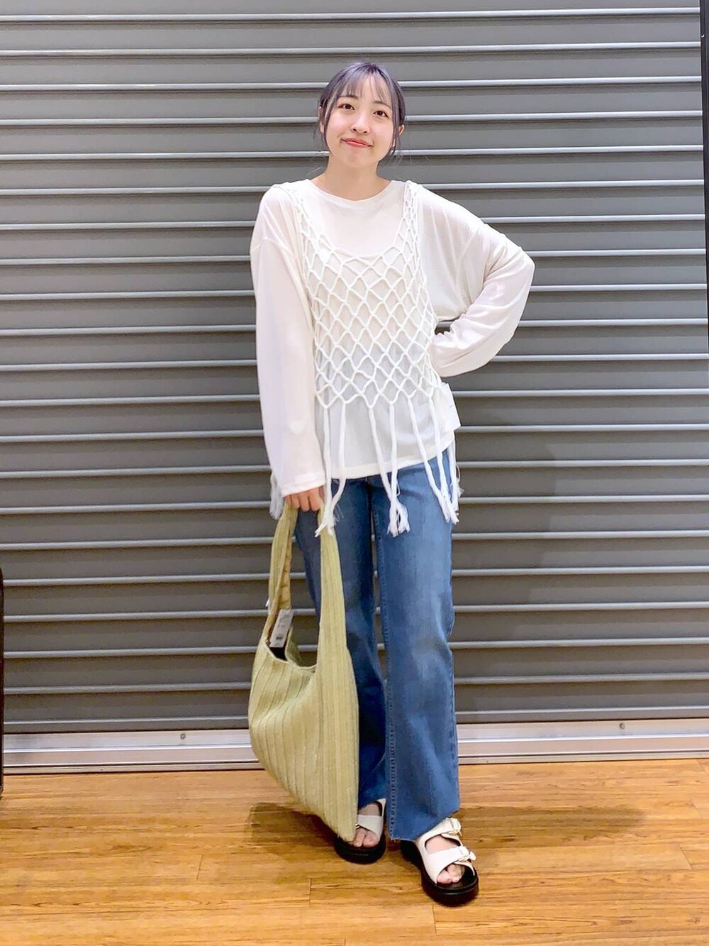 ホワイト系のTシャツ/カットソー、ホワイト系のベスト、ブルー系のデニムパンツを着用したレディースの春コーディネートの2枚目の写真