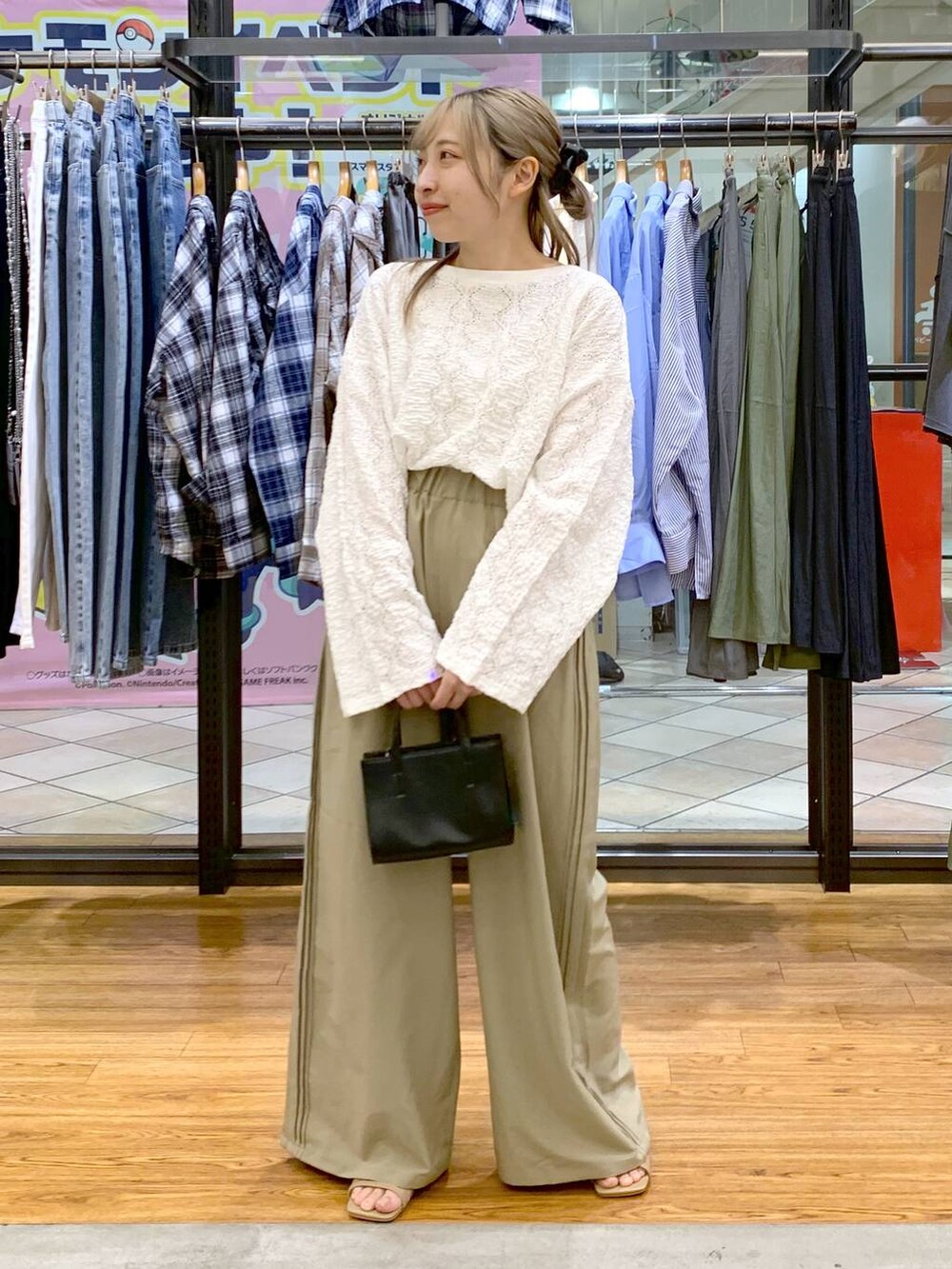 ブラック系のショルダーバッグ、ベージュ系のその他パンツ、ホワイト系のTシャツ/カットソーを着用したレディースの春コーディネートの3枚目の写真
