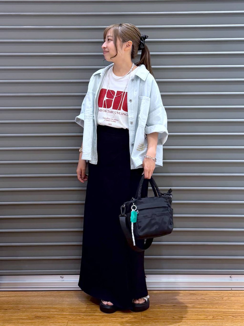 ブラック系のスカート、ホワイト系のTシャツ/カットソー、ブラック系のトートバッグを着用したレディースの夏コーディネートの5枚目の写真