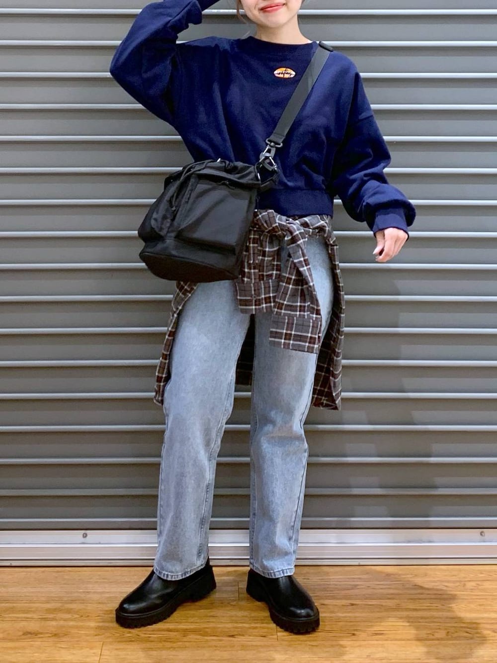 ブラック系のショルダーバッグ、ブルー系のデニムパンツ、ブラック系のブーツを着用したレディースの冬コーディネートの7枚目の写真