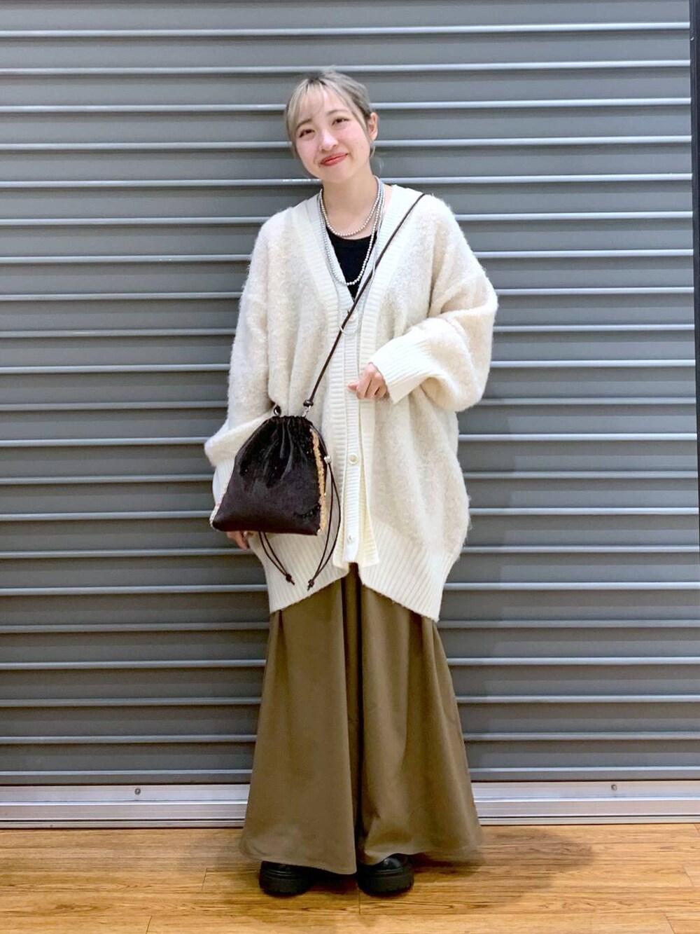 ブラウン系のその他パンツ、ホワイト系のカーディガン/ボレロ、ブラウン系のショルダーバッグを着用したレディースの秋コーディネートの6枚目の写真