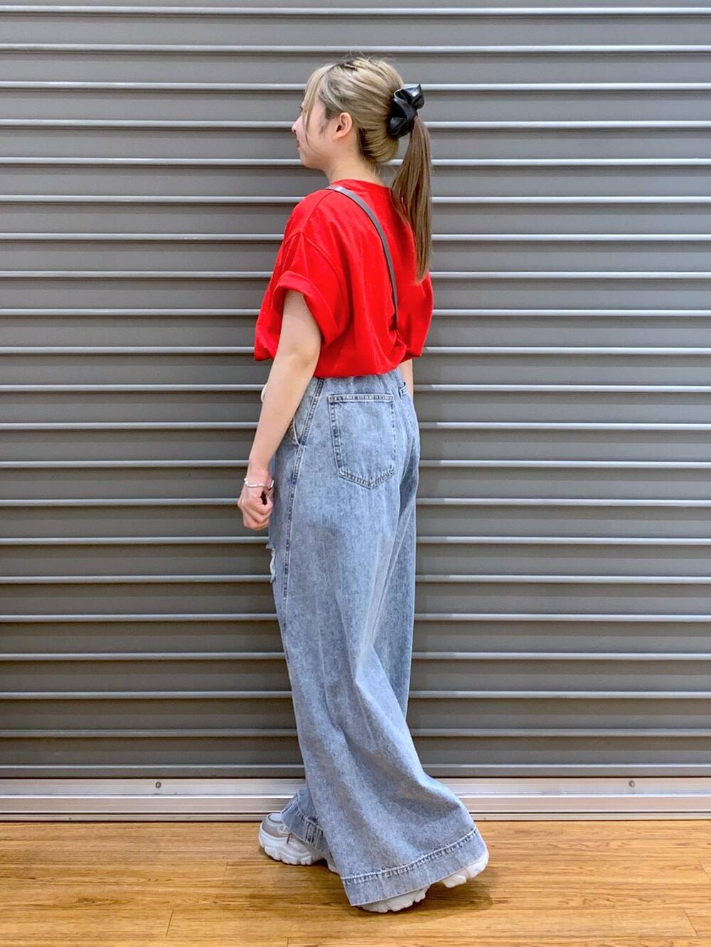 ブルー系のデニムパンツ、シルバー系のスニーカー、レッド系のTシャツ/カットソーを着用したレディースの夏コーディネートの3枚目の写真