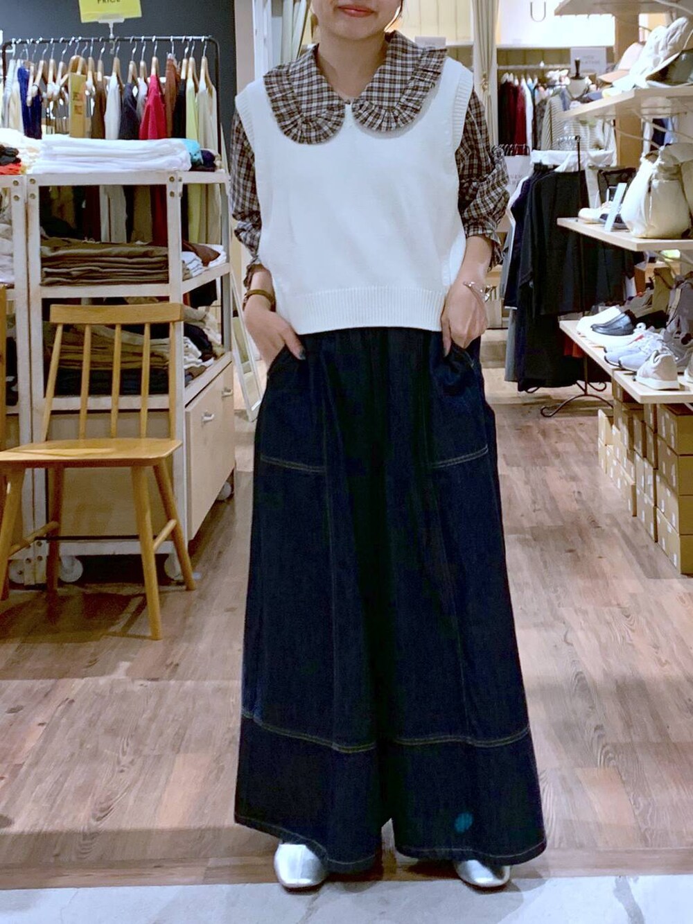 ホワイト系のベスト、ブルー系のデニムパンツ、その他のパンプスを着用したレディースの秋コーディネートの2枚目の写真