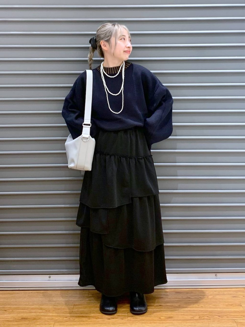 ブルー系のニット/セーター、グレー系のショルダーバッグ、ブラック系のブーツを着用したレディースの冬コーディネートの6枚目の写真