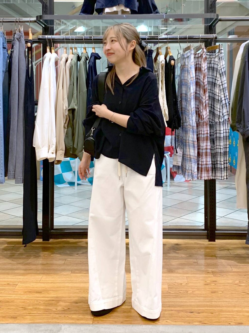 ブルー系のシャツ/ブラウス、ブラック系のローファー、ホワイト系のデニムパンツを着用したレディースの春コーディネートの6枚目の写真