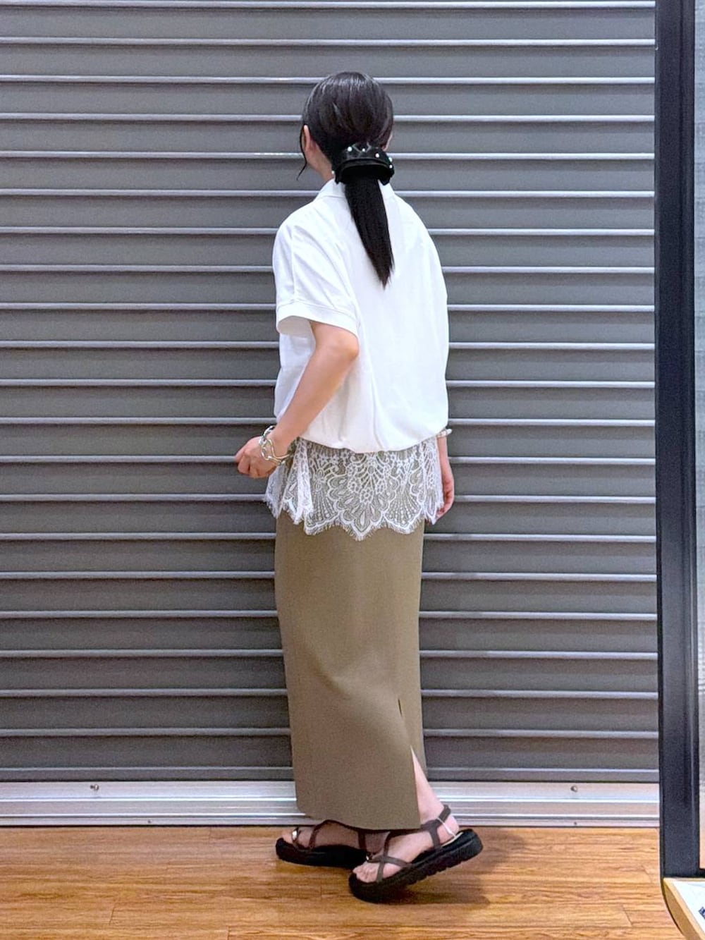 グリーン系のスカート、ブラウン系のサンダル、ホワイト系のTシャツ/カットソーを着用したレディースの夏コーディネートの3枚目の写真