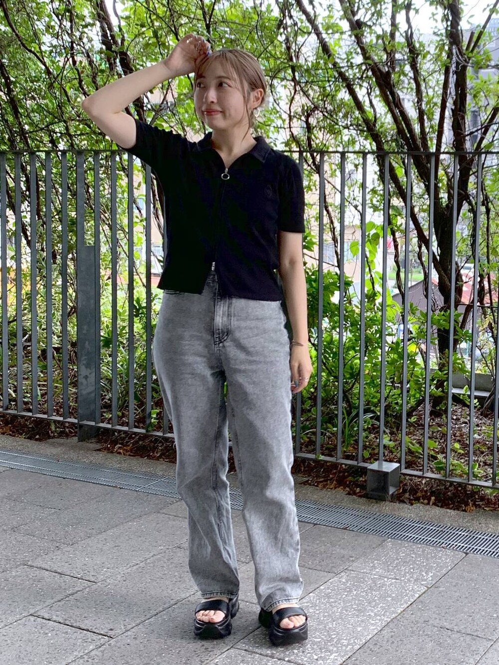 ブラック系のショルダーバッグ、ブラック系のサンダル、グレー系のデニムパンツを着用したレディースの夏コーディネートの2枚目の写真