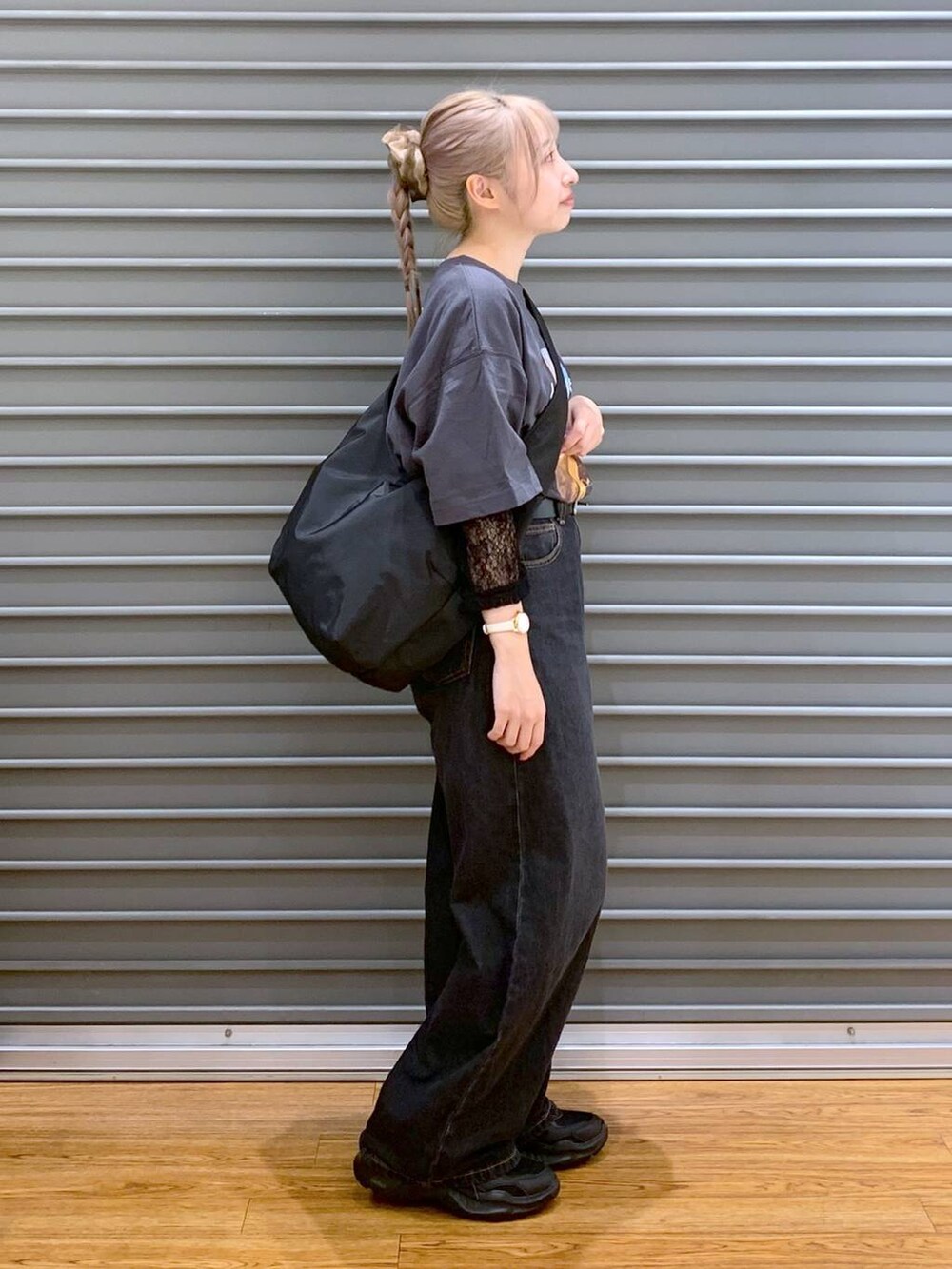 ブラック系のデニムパンツ、ブラック系のスニーカー、ブラック系のショルダーバッグを着用したレディースの秋コーディネートの6枚目の写真