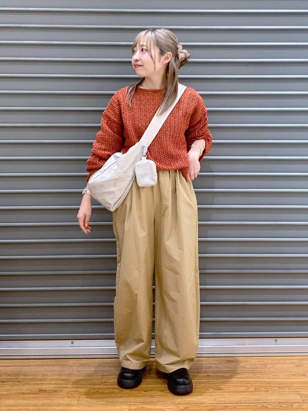 レッド系のニット/セーター、ホワイト系のショルダーバッグ、ブラック系のサンダルを着用したレディースの春コーディネートの4枚目の写真