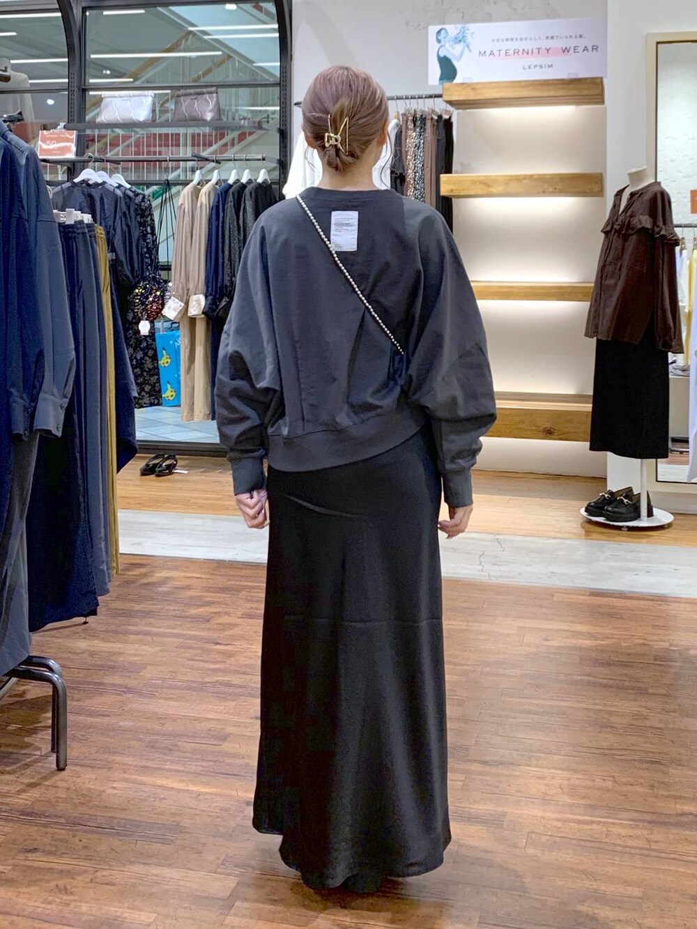 シルバー系のショルダーバッグ、ブラック系のスカート、ブラック系のローファーを着用したレディースの秋コーディネートの2枚目の写真