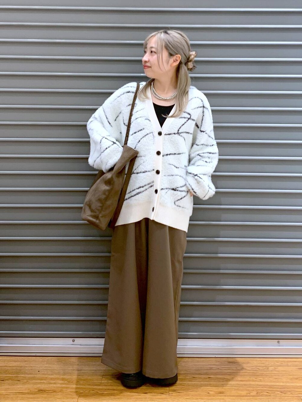 ブラウン系のその他パンツ、ホワイト系のカーディガン/ボレロ、ブラック系のブーツを着用したレディースの秋コーディネートの5枚目の写真