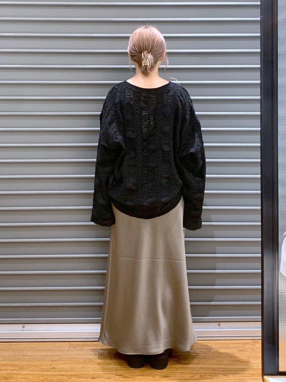 ブラック系のTシャツ/カットソー、ブラウン系のスカート、ホワイト系のボストンバッグを着用したレディースの秋コーディネートの2枚目の写真