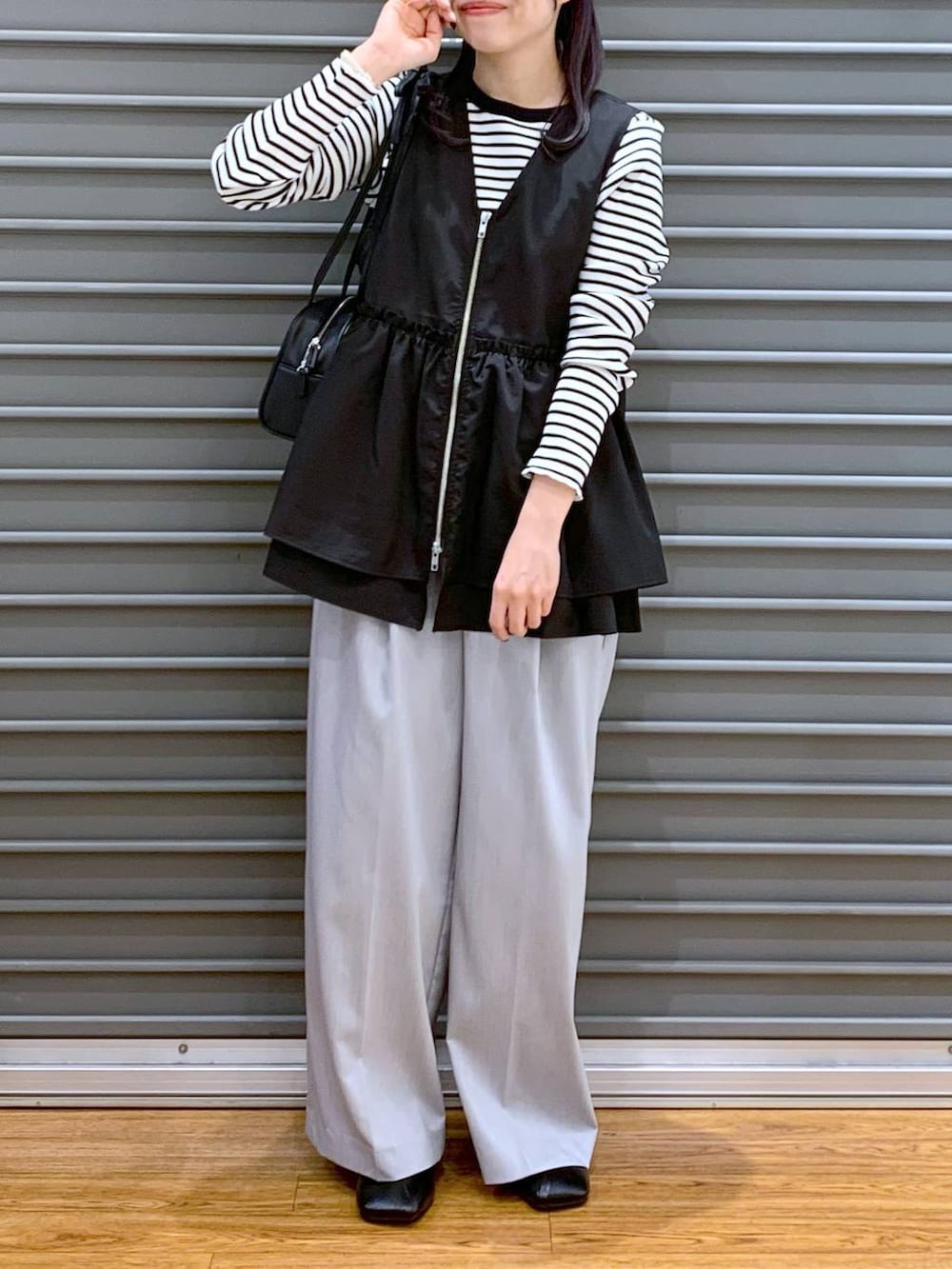 ブラック系のショルダーバッグ、ブラック系のパンプス、ブラック系のベストを着用したレディースの春コーディネートの8枚目の写真