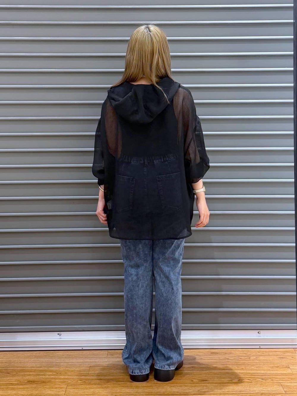 ブラック系のサンダル、ブルー系のデニムパンツ、グレー系のタンクトップを着用したレディースの春コーディネートの2枚目の写真