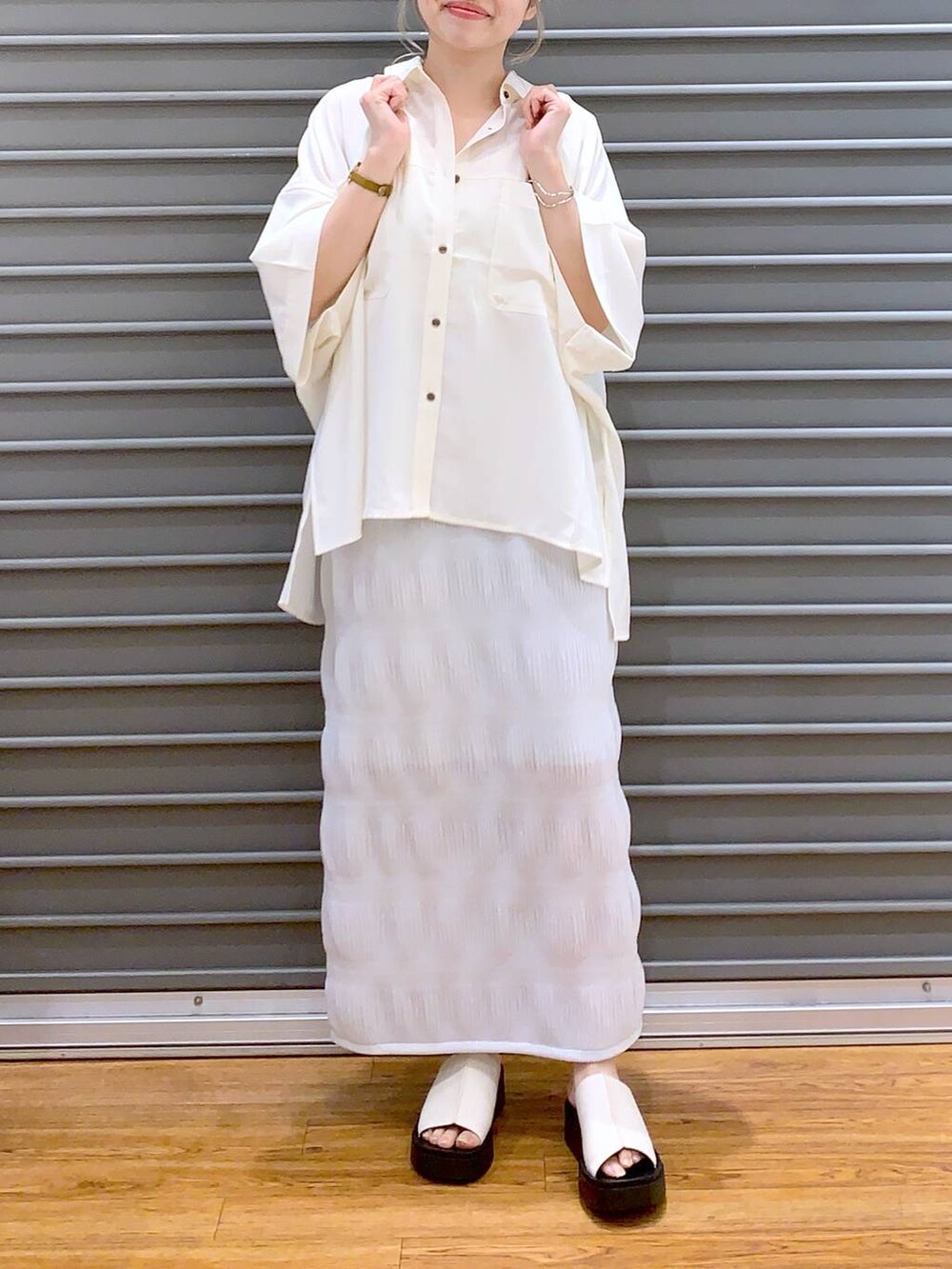 ブラック系のショルダーバッグ、ホワイト系のサンダル、ホワイト系のシャツ/ブラウスを着用したレディースの夏コーディネートの4枚目の写真