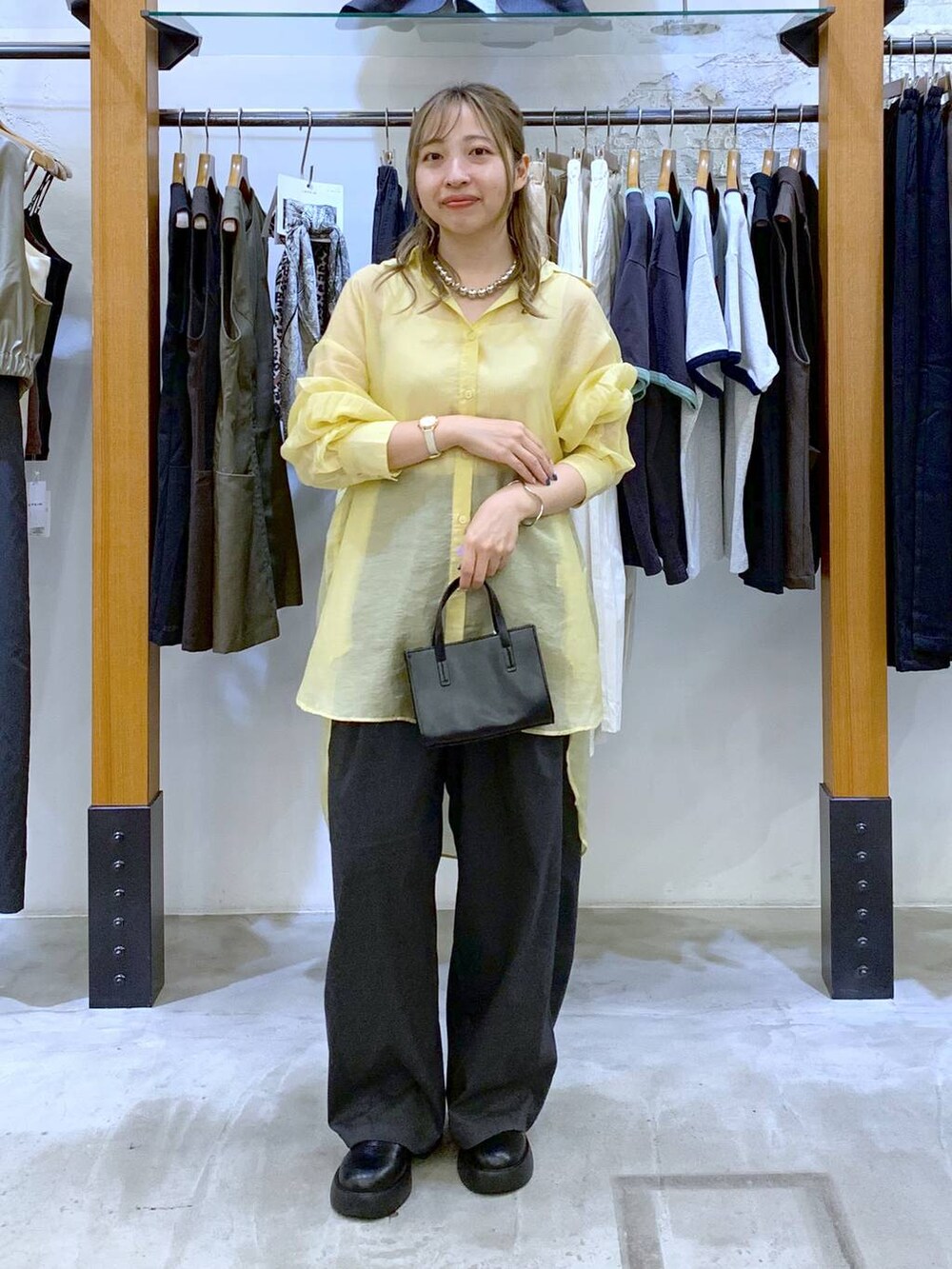 ホワイト系のタンクトップ、ブラック系のショルダーバッグ、イエロー系のシャツ/ブラウスを着用したレディースの秋コーディネートの4枚目の写真